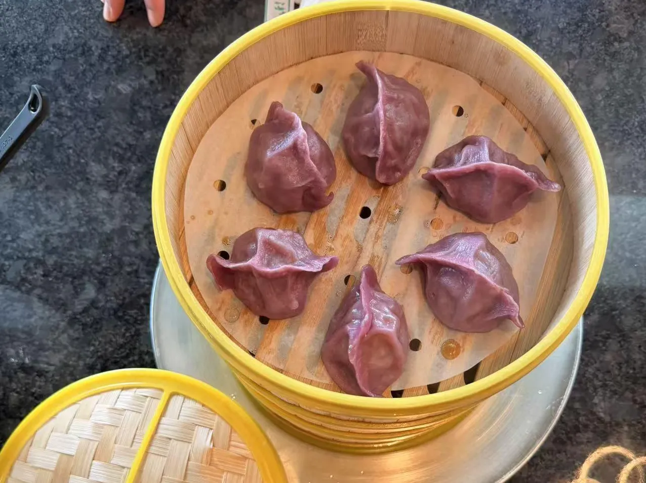 Steamed purple dumplings in bamboo steamer at Bobo Noodles And Dumplings, a Chinese Restaurant in Omaha